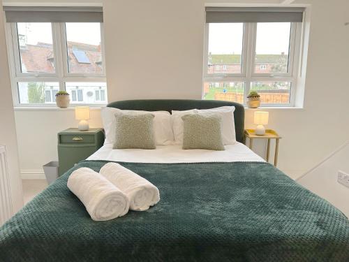 een slaapkamer met een groot bed en 2 handdoeken bij Cotswold's Large 4 bed house-Sleeps 10-Free Parking-Wifi 