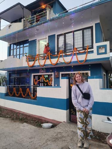 a woman is standing in front of a building at KIRTIPUR COMFORT HOMESTAY with breakfast & dinner in Kirtipur