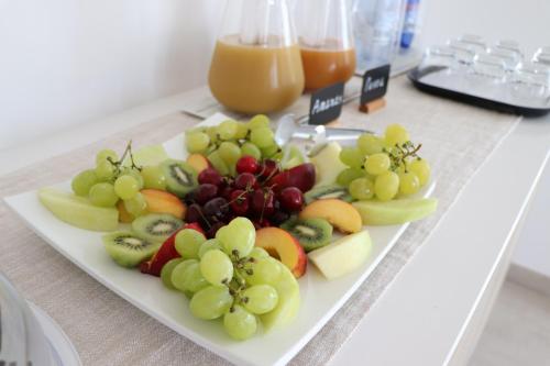 un piatto di frutta su un tavolo con del succo di Verde Blu Vacanze B&B a Torre Lapillo