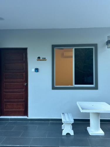 a blue wall with a bench and a window and a door at Guest House Gua Kelam in Kaki Bukit