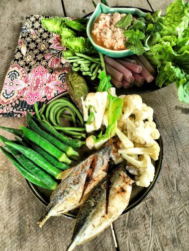 a plate of food with fish and vegetables on a table at Banteay Srey Women's Only Traditional Spa and Homestay in Kampot