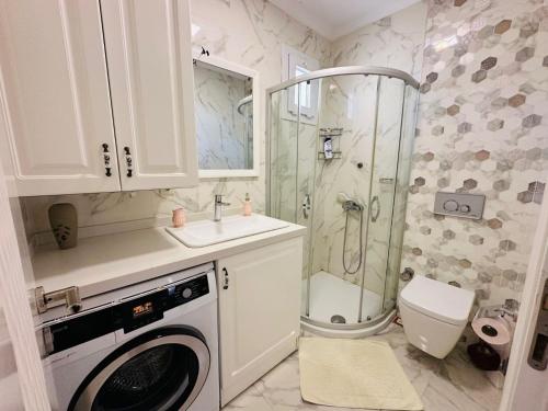 a bathroom with a shower and a washing machine at Evalacati - Villa Palma-Tamamen Müstakil Villa in Cesme
