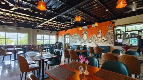 een restaurant met houten tafels en stoelen en oranje muren bij NH16 Farm Stay And Restaurant in Chāndpur