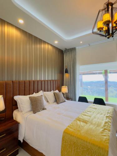 a bedroom with a large bed and a large window at Misty Wonders in Munnar