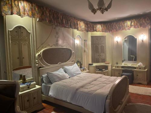 a bedroom with a large bed and a mirror at المهندسين شقه سوبر لوكس - محى الدين ابو العز in Cairo