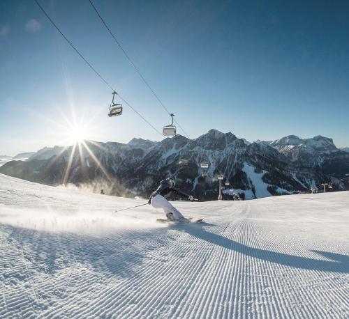 a person skiing down a snow covered slope with a ski lift at Residenz Feldmühle unterhalb der Burg Taufers in Campo Tures