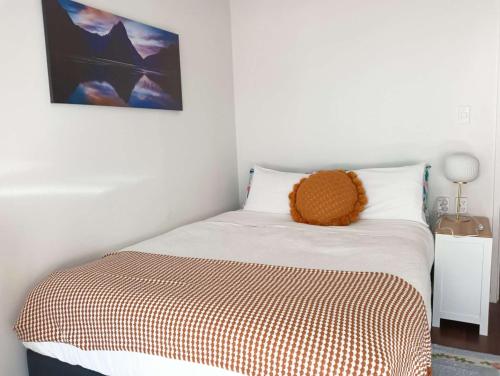 a bed with a teddy bear sitting on top of it at Sweet Home between CBD and University in Hamilton