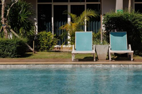 two blue and white chairs sitting next to a swimming pool at Southern Airport Hotel Hatyai in Hat Yai