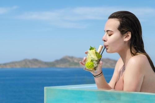 a woman eating a salad in a swimming pool at Hotel Senia - Onar Hotels Collection in Naousa