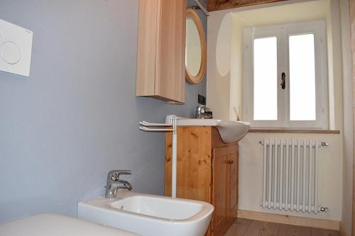 ein Bad mit einem Waschbecken, einem Spiegel und einem Fenster in der Unterkunft Alla Valle in Gallio