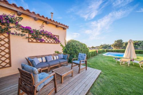 a backyard with a wooden deck with chairs and a pool at Sissi Hills Villa in Sissi