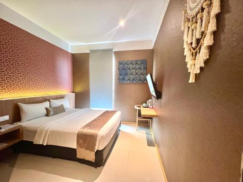 Habitación de hotel con cama y TV en Deli Hotel, en Medan