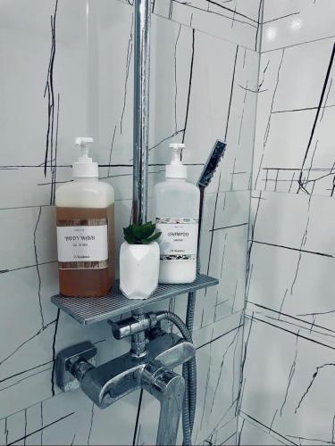 a bathroom with three bottles of soap and a sink at GataBagajul Apartments - Vaslui in Vaslui