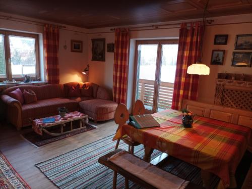 a living room with a table and a couch at Dopplerhof's Staufenhaus in Piding