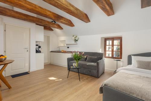 a bedroom with a bed and a couch and a kitchen at Old Town South Gate Apartment in Kotor