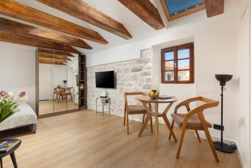 a living room with a table and chairs at Old Town South Gate Apartment in Kotor