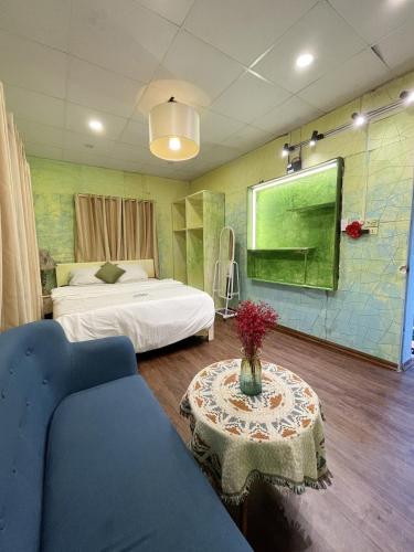 a room with two beds and a table and a couch at Luna Homestay in Hanoi