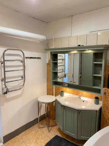 a bathroom with a sink and a mirror and a stool at Cosy 2 room 55m2 Centric 10min to Old Town AC in Rīga