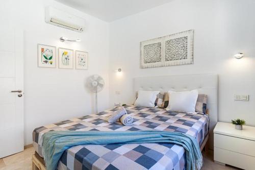 um quarto com uma cama com um cobertor xadrez azul e branco em Luxuriösen Apartment am Meer Golfplatz, Strand em Playa del Cura