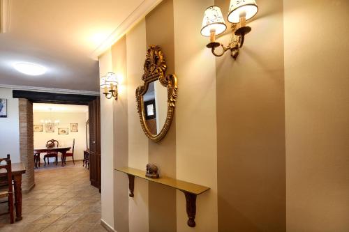 a hallway with a mirror on the wall and a table at Apartamentos Teresana in Alquézar