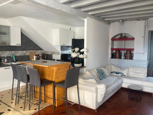 une cuisine et un salon avec une table et un canapé dans l'établissement La Maison du soleil L Aulhere 3 étoiles ,Maison familiale 6-7 personnes, Jacuzzi , Massages bien-être en option, à Oloron-Sainte-Marie