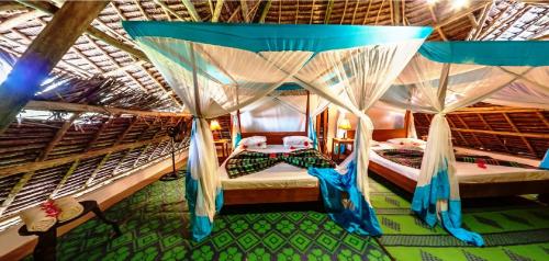 1 Schlafzimmer mit 2 Betten und Moskitonetzen in der Unterkunft FULLY PRIVATE VILLA 390sqm ZERO MINUTES TO BEACH MATEMWE in Gazija