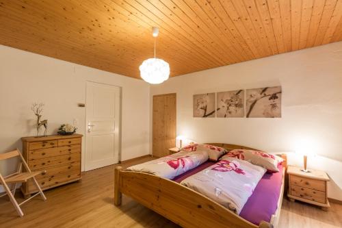 a bedroom with a bed and a wooden ceiling at Chasa Silvretta in Scuol