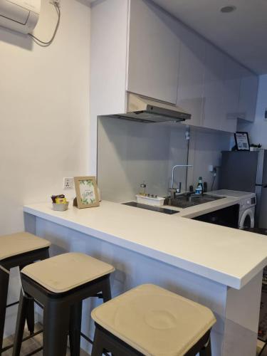 a kitchen with a counter with stools and a counter top at HarbourBay Residence. Batam. Studio. 1min to Ferry in Jodoh