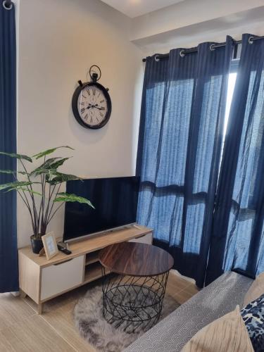 a room with blue curtains and a clock on the wall at HarbourBay Residence. Batam. Studio. 1min to Ferry in Jodoh