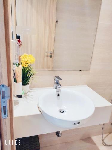 a bathroom with a sink and a mirror and flowers at YLY Homestay Hạ Long in Ha Long