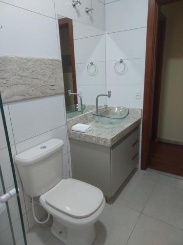 a bathroom with a toilet and a sink at Alto padrão !Forno Pizza! Hidro !Vista linda! in Poços de Caldas
