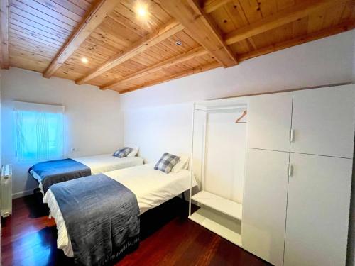 アーロにあるAPARTAMENTO CONDE DE HAROの木製天井のドミトリールーム ベッド2台