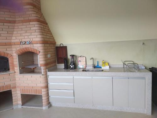 a kitchen with a brick oven and a counter top at Alto padrão !Forno Pizza! Hidro !Vista linda! in Poços de Caldas
