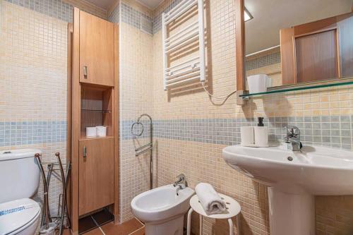 Un baño con lavabo e inodoro en Holidays, Arttyfal, 2 Dormitorios para 4 personas, parking y wi-fi, en Sierra Nevada