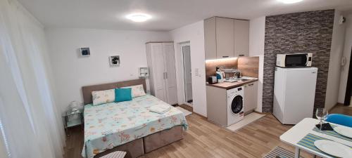 ein kleines Schlafzimmer mit einem Bett und einer Küche in der Unterkunft Aloha in Burgas City