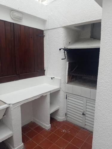 a bathroom with a white sink and wooden cabinets at Refugio Atlántico in San Bernardo