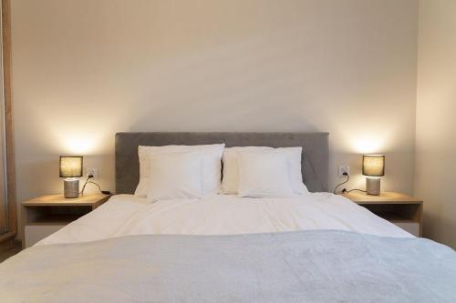 een slaapkamer met een bed met twee lampen op tafels bij VacationClub – Spokojna 24I Apartament 1 in Wisła