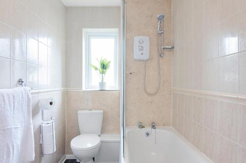 ein weißes Bad mit einem WC und einer Dusche in der Unterkunft Elegance Graceland in Gillingham