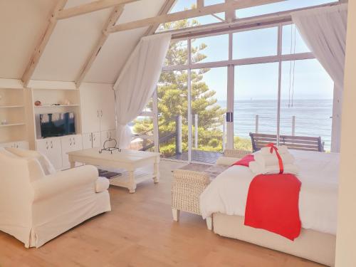 a bedroom with a bed and a view of the ocean at Whales Way Ocean Retreat in Wilderness