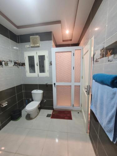 a bathroom with a toilet and a door in it at Blue Nile House in Luxor