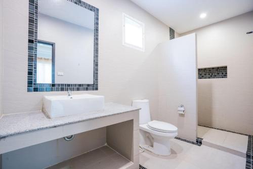 W łazience znajduje się umywalka, toaleta i lustro. w obiekcie Space X Slider 4 Bedrooms Pool Villa Huahin w mieście Hua Hin