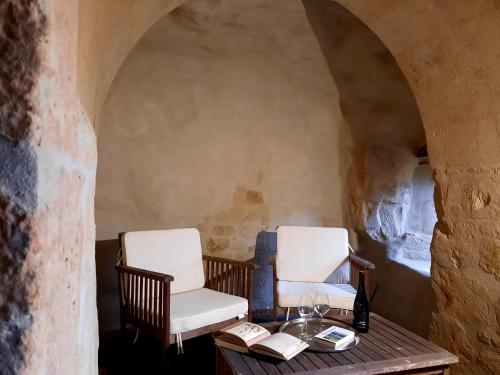 two chairs and a table with wine glasses and books at Gite 4* L'Orée des Fleurs in Grézillé