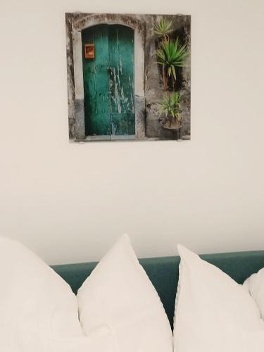 a green door on a wall with white pillows at Cozy Stay Apartments in Salzburg