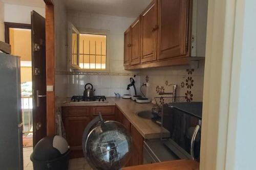 - une cuisine avec des placards en bois et un grand bol dans l'établissement T2 Cap d'Agde bord Roquille, au Cap d'Agde