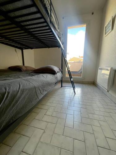 - une chambre avec des lits superposés et du carrelage dans l'établissement T2 Cap d'Agde bord Roquille, au Cap d'Agde