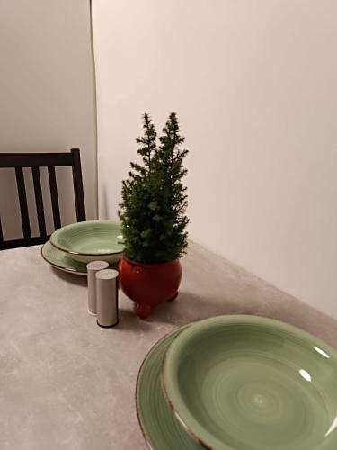 a table with two green plates and a christmas tree at Cozy Stay Apartments in Salzburg