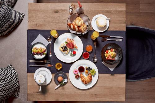 uma mesa coberta com pratos de alimentos e bebidas em Panorama Samnaun em Samnaun