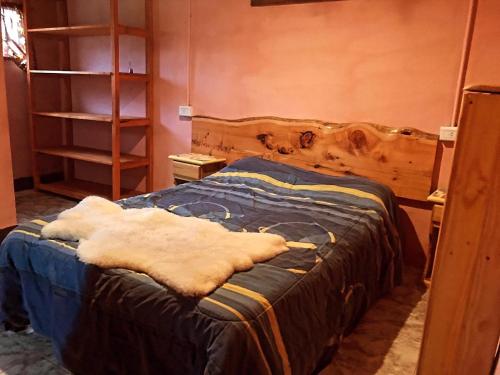 1 dormitorio con 1 cama con manta azul en Don Martin en El Bolsón
