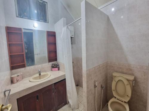 y baño con aseo y lavamanos. en Villa Kota Bunga EE3-15 en Cikundul