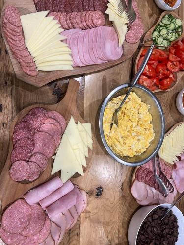 uma mesa com diferentes tipos de carnes e queijos em Hotel Muntele Mic em Borlova